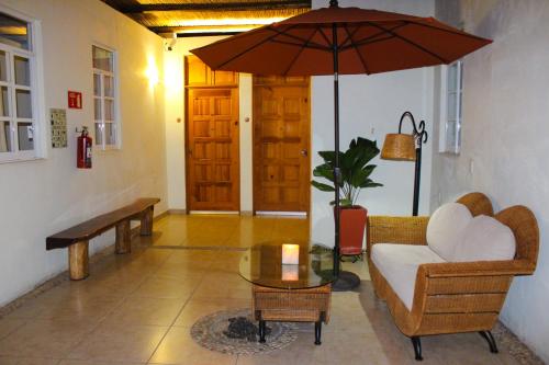 a living room with a couch and an umbrella at Hotel Careyes Puerto Escondido in Puerto Escondido