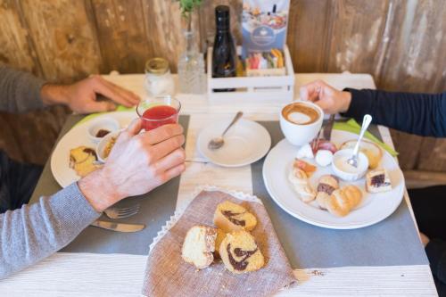 two people sitting at a table with food and drinks at Dimore Trulli Holiday in Alberobello