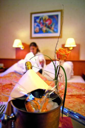a table with a vase with a flower in a hotel room at Hotel Die Kleine Blume in Erfweiler