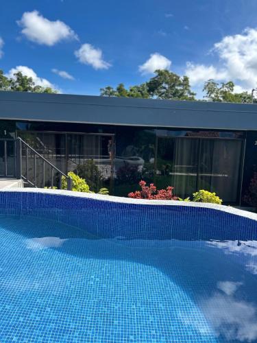 a swimming pool in front of a house at Residencia Esmeralda in Agua Buena