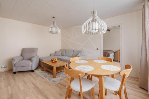 a kitchen and living room with a table and chairs at Kuuse 4 Apartment in Haapsalu