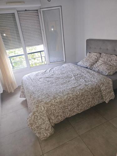 une chambre avec un lit et deux fenêtres dans l'établissement Logement terrasse chute la vie, à Marseille