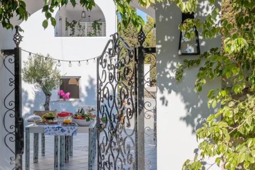 an open gate to a garden with a table and flowers at Oltremare Inn in Spetses