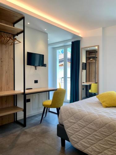 レードロにあるHotel Locanda Alla Perlaのベッドと机と椅子のある寝室