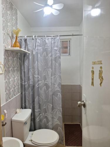 a bathroom with a shower curtain and a toilet at More than Space Staycation in Sampong