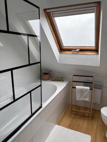 une salle de bain avec une baignoire et une fenêtre dans l'établissement Les hortensias de papy, à Plozévet