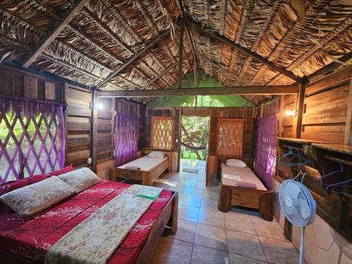 a bedroom with a bed in a room with a roof at Wildlife Lodge Cahuita in Cahuita