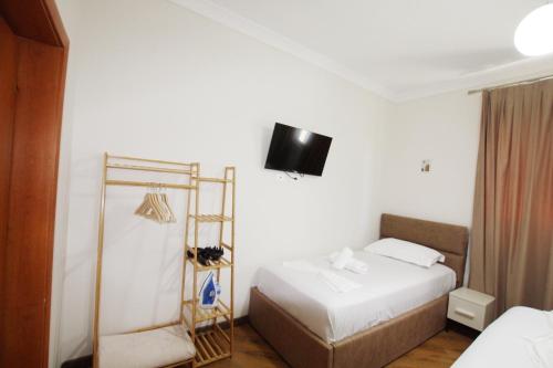 a bedroom with a bed and a tv on the wall at Villa Reve de Tirana in Tirana