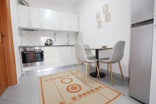 a kitchen with a table and two chairs and a rug at Villa Reve de Tirana in Tirana