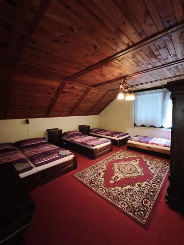 a room with four beds and a rug on the floor at Apartmány Na vyhlídce in Blata