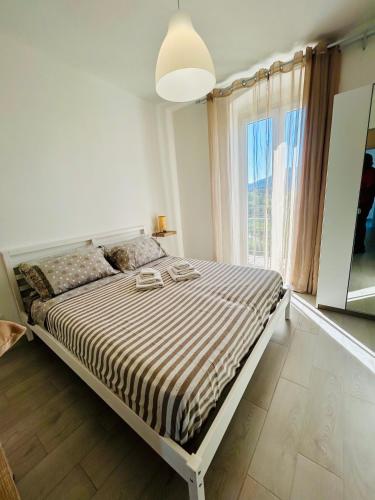 a bed in a bedroom with a large window at Casa Sbollazza con parcheggio e vicino al parco in Sestri Levante