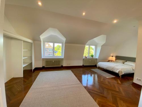 a large bedroom with a bed and a window at Design-Loft mit 2 Balkonen am Stadtwald - 20 min zur Messe Düsseldorf in Krefeld