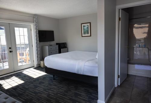 a bedroom with a bed and a sliding glass door at Park Lane Motel in Lake George