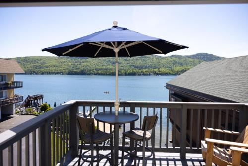 a table and two chairs under an umbrella on a balcony at Park Lane Motel in Lake George