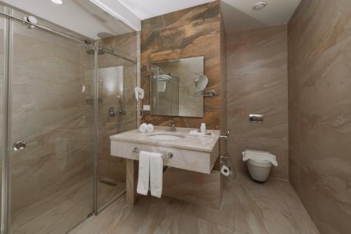 un baño con lavabo y ducha en City Park Inn Baku, en Baku