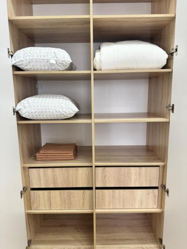 a wooden book shelf with pillows on it at A-Six Apartment ЖК Family park in Karagandy