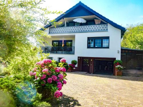 Una casa con flores rosas en el frente. en Ferienwohnung Haus Seeblick Geltow, en Schwielowsee