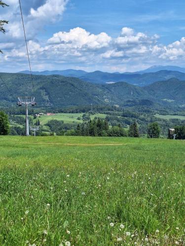 a field of grass with mountains in the background at Rekreačná chata in Banská Bystrica