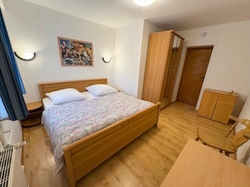 Un dormitorio con una cama y suelo de madera. en Ferienwohnung Haus Seeblick Geltow, en Schwielowsee