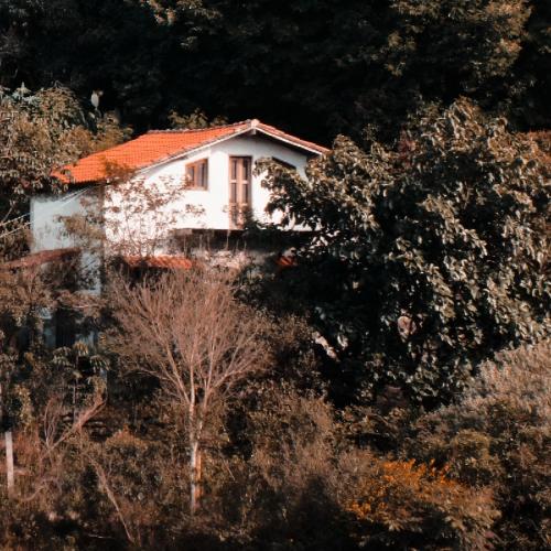 a white house on a hill with trees at Casa Arte Rupestre in Ibicoara