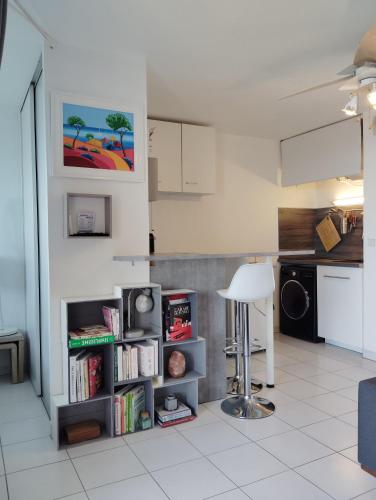 une cuisine avec une étagère et des livres dans l'établissement Beau Studio au calme avec coin nuit, à Grasse