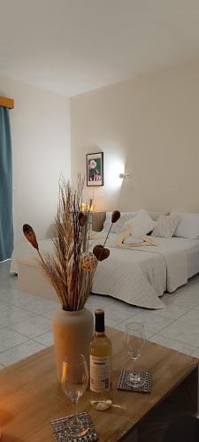 a room with a bed and a table with two wine glasses at Pyrgos Hotel Apartments in Kremasti