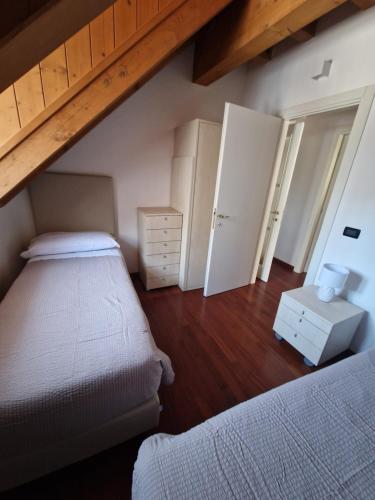 a bedroom with two beds and a wooden floor at Hotel Raibl e Appartamenti in Tarvisio