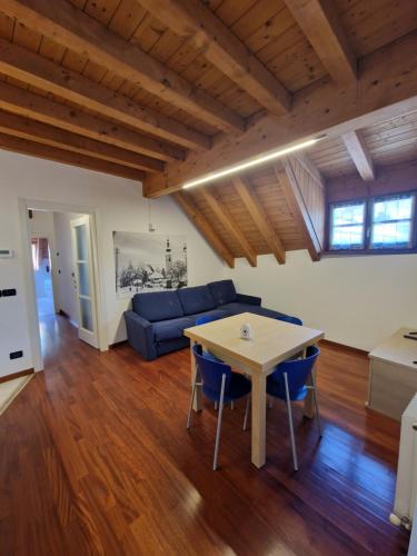 a living room with a blue couch and a table at Hotel Raibl e Appartamenti in Tarvisio