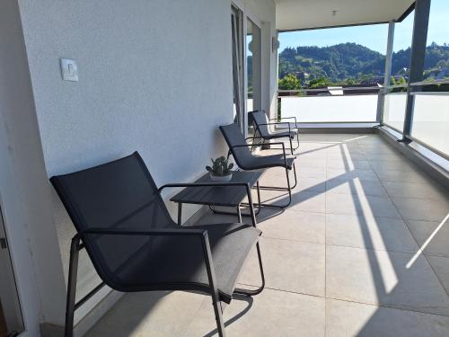 three chairs and a table on a balcony at Panorama-FREE PARKING-BREAKFAST-TERACCE in Vojnik