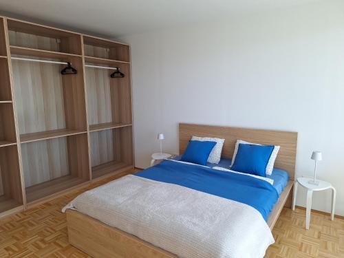 a bedroom with a large bed with blue pillows at Panorama-FREE PARKING-BREAKFAST-TERACCE in Vojnik