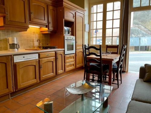 une cuisine avec une table, des chaises et un canapé dans l'établissement Conques en Rouergue, maison de village,Grand Vabre, à Conques-en-Rouergue