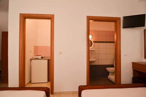 a room with a refrigerator and a small bathroom at Giannis Hotel in Paralia Katerinis