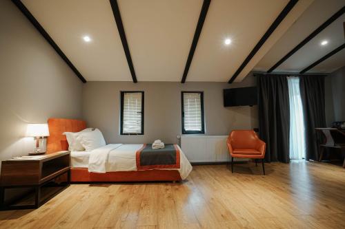 a bedroom with a bed and a desk and a chair at Boutique Hotel Kviria in Tʼelavi