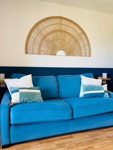 un canapé bleu avec des coussins dans un salon dans l'établissement Studio à Gréoux les bains - Les Fontaines, à Gréoux-les-Bains