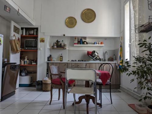une cuisine avec une table et des chaises dans une pièce dans l'établissement Chez Floriane, à Marseille