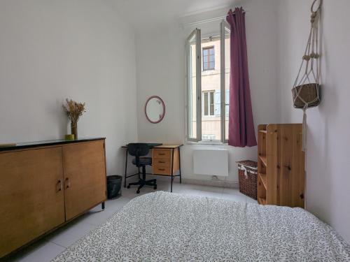 une chambre avec un lit, une commode et une fenêtre dans l'établissement Chez Floriane, à Marseille