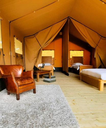 a room with a bed and a chair in a tent at Chrysalide in Varen