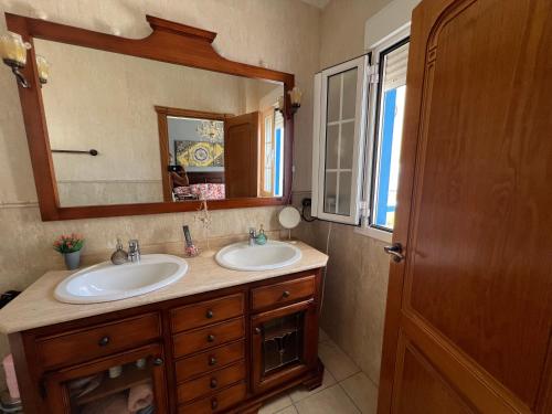 a bathroom with two sinks and a large mirror at Salamandra in Carboneras