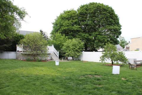 a yard with a white fence and trees and a house at NEW! Family-Friendly Getaway -1 Mi to Dtwn Salem w Roof Deck & Tiki Bar in Salem