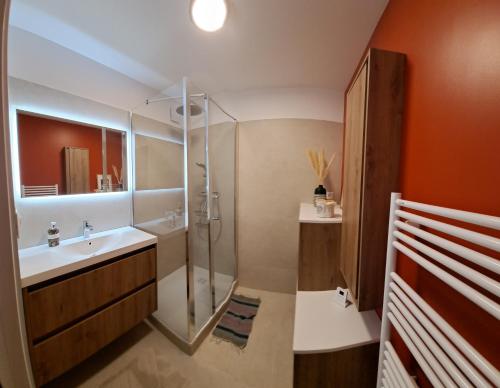 a bathroom with a glass shower and a sink at Le petit du Barry in Millau