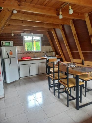 una grande cucina con tavolo e frigorifero di Cabañas Sueño Serrano a Saldungaray