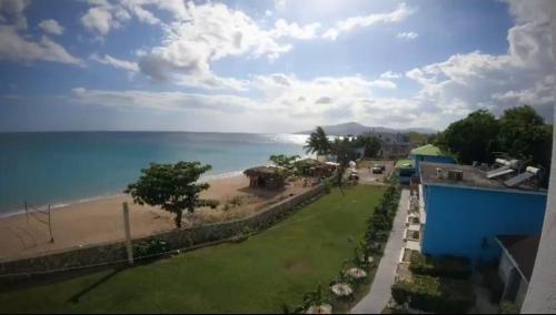 a view of the beach from the balcony of a house at The Grand Begonia Beach Hotel in Water Valley