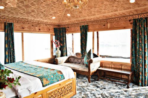 a bedroom with a bed and a chair and windows at Honolulu Group Of Houseboats in Srinagar