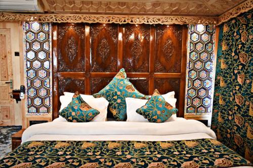 a bedroom with a bed with a wooden headboard and pillows at Honolulu Group Of Houseboats in Srinagar