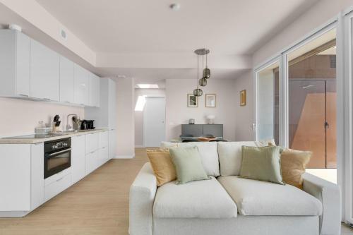 a white living room with a couch and a kitchen at Airy Apartments with Balcony & Garage in Milan