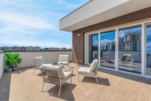 a patio with chairs and a table on a balcony at Airy Apartments with Balcony & Garage in Milan
