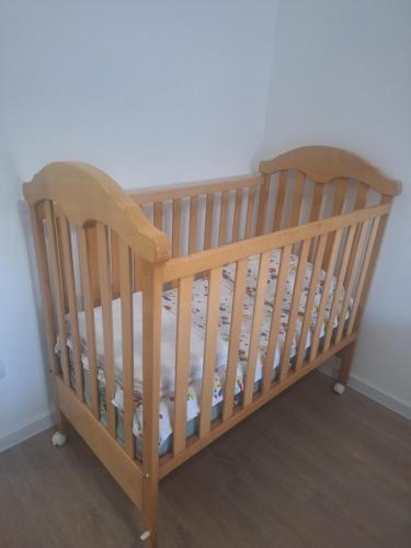 a wooden crib in a corner of a room at Apartman L&S in Doboj