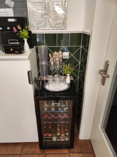 a small cabinet with flowers and vases on it at Unterwegs ins Apartmenthaus ehemalige Apartmenthaus Unterwegs in Rostock