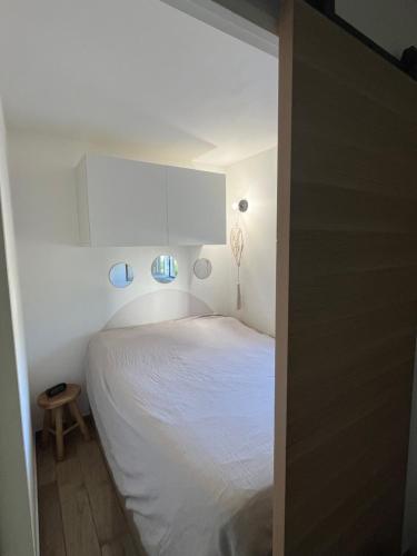 - une chambre avec un lit blanc et une armoire blanche dans l'établissement Appartement proche de la mer, à La Ciotat