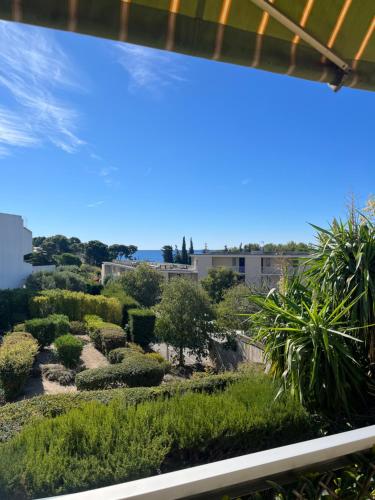 Elle offre une vue sur le jardin depuis sa fenêtre. dans l'établissement Appartement proche de la mer, à La Ciotat